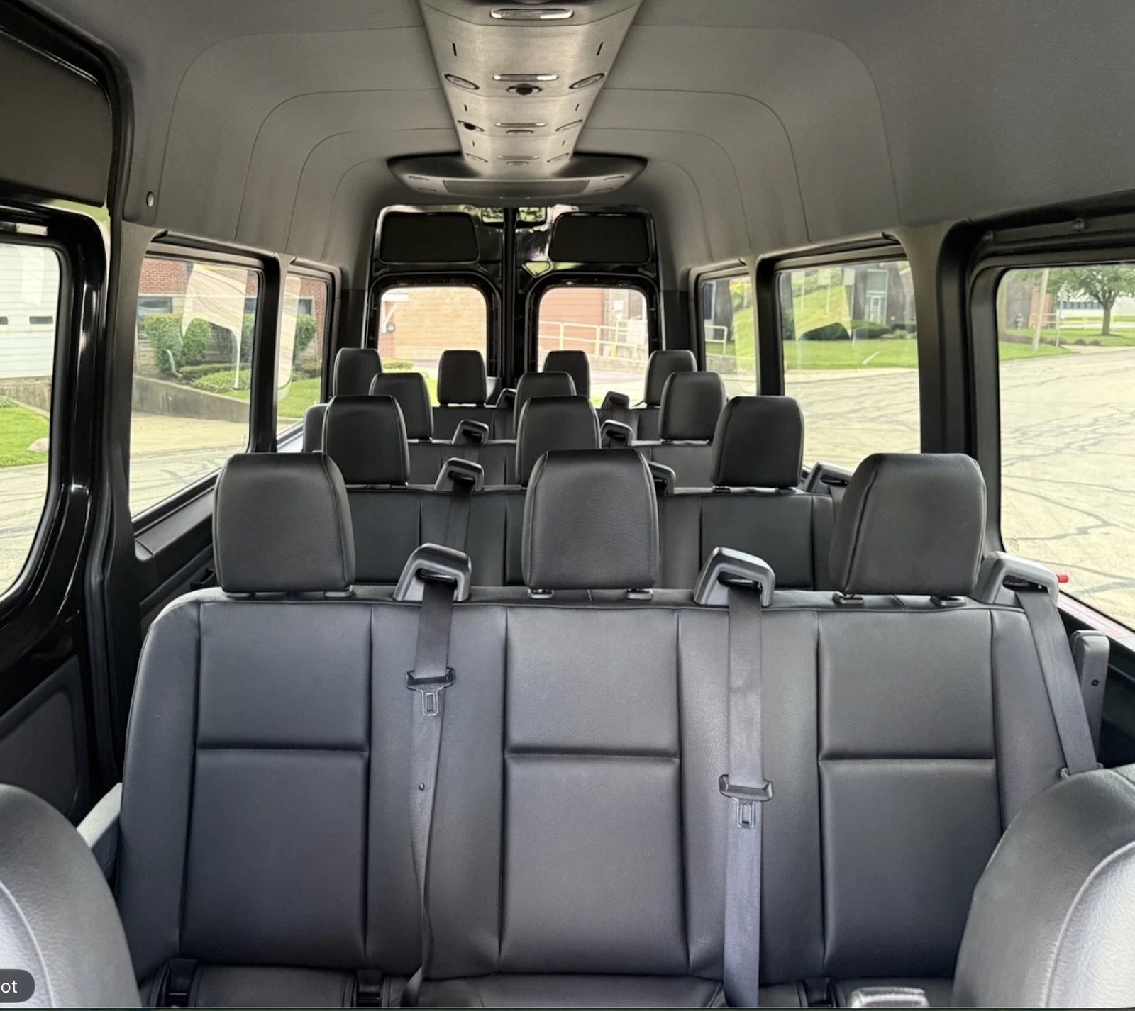 View from the rear of the Boston Party Van interior showing rows of black passenger seating