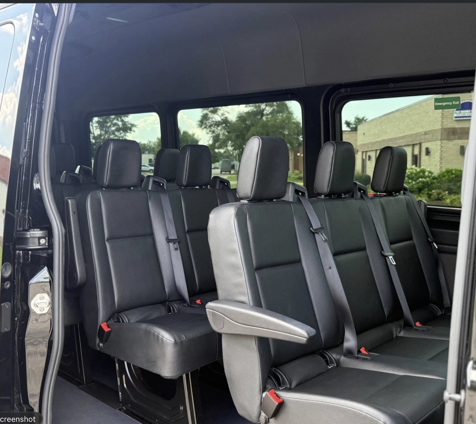 Side-entry view of the Boston Party Van interior showing black passenger seats and armrests